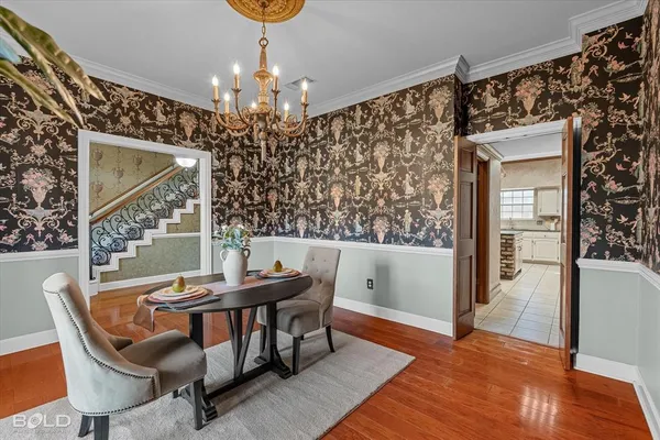 a dining room with furniture a chandelier and wooden floor