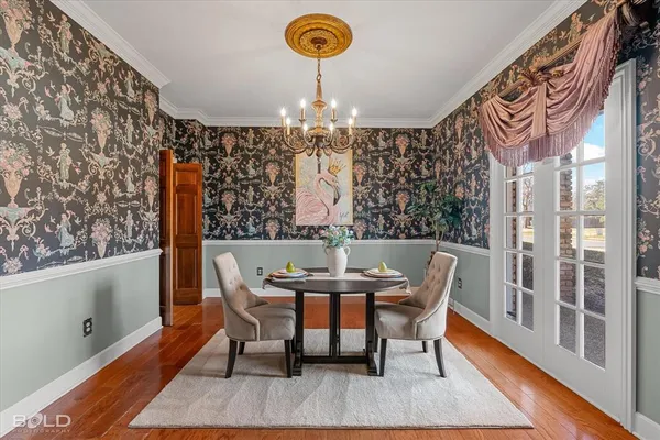 a view of a dining room with furniture a chandelier and wooden floor
