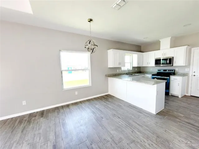 a kitchen with appliances cabinets a sink and a window