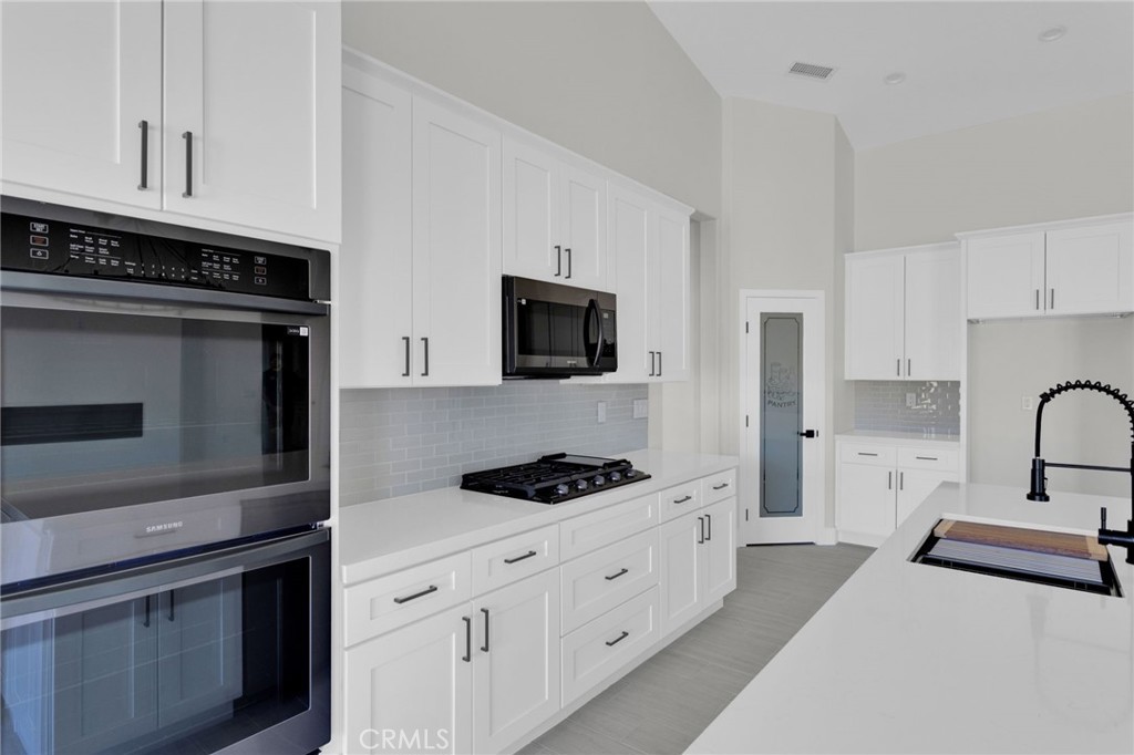16339 Rimrock Road Apple Valley, CA 92307 - Photo 14 of 50 a kitchen with stainless steel appliances a stove microwave and cabinets