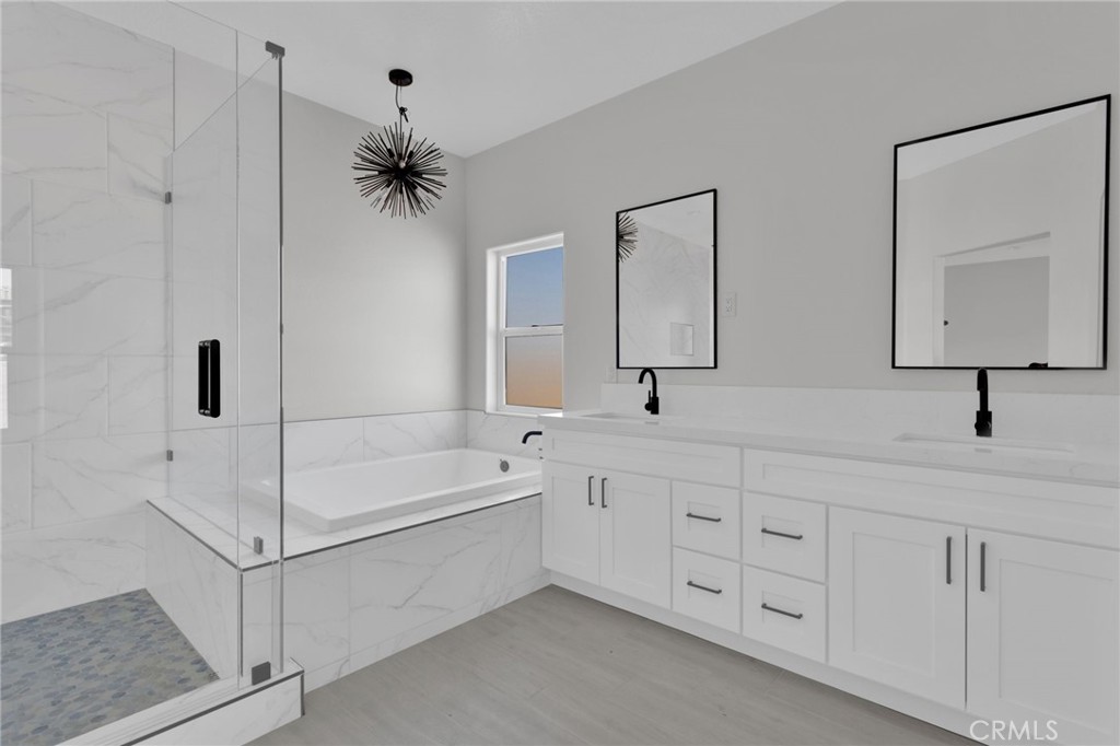 16339 Rimrock Road Apple Valley, CA 92307 - Photo 18 of 50 a bathroom with a double vanity sink a mirror and a bathtub