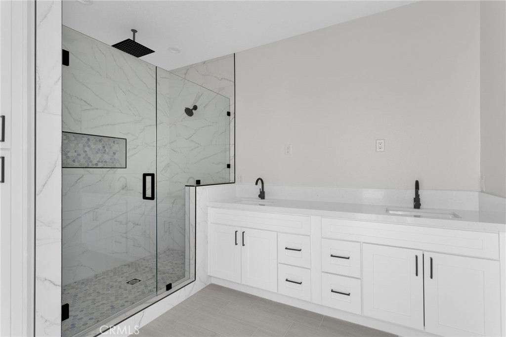 16339 Rimrock Road Apple Valley, CA 92307 - Photo 32 of 50 a bathroom with a granite countertop sink a mirror and a shower