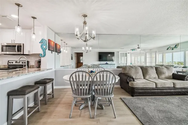 a living room with furniture kitchen view and a chandelier