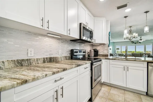 a kitchen with stainless steel appliances granite countertop a stove a sink and a refrigerator