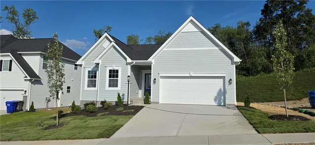 a view of a white house next to a yard with big trees