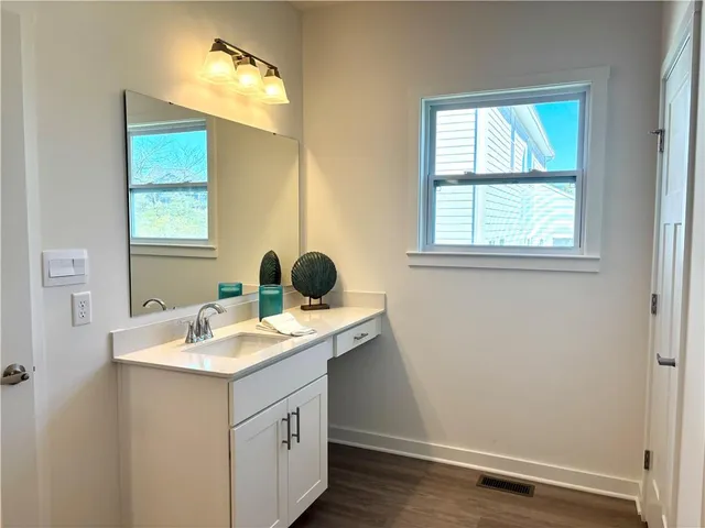 a bathroom with a sink a vanity and a window