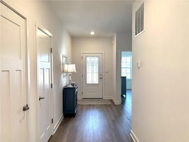 a view of a hallway with wooden floor and stairs