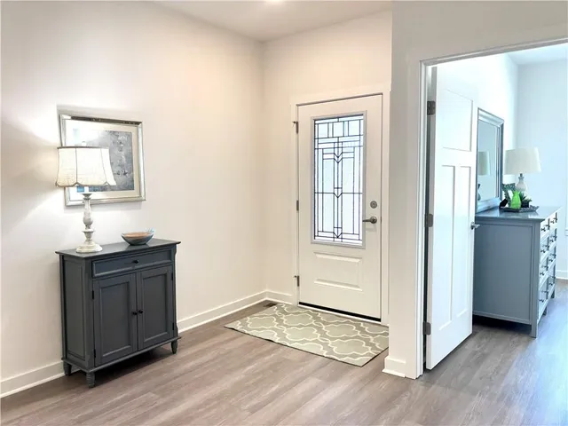 an empty room with wooden floor cabinet and mirror