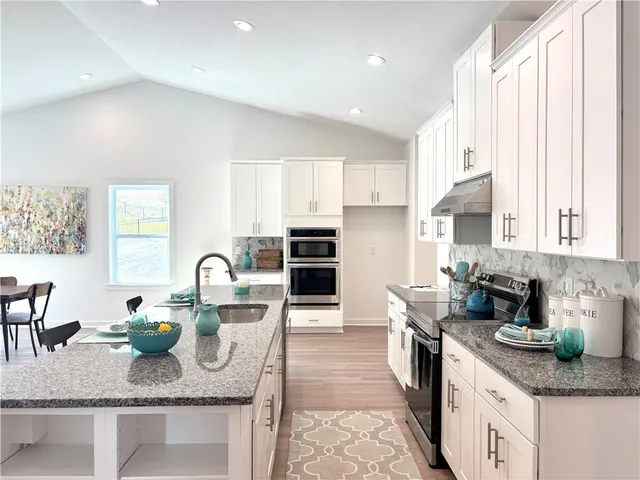 a kitchen with granite countertop a stove a sink and a granite counter tops