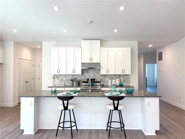 a kitchen with stainless steel appliances kitchen island a large window and cabinets