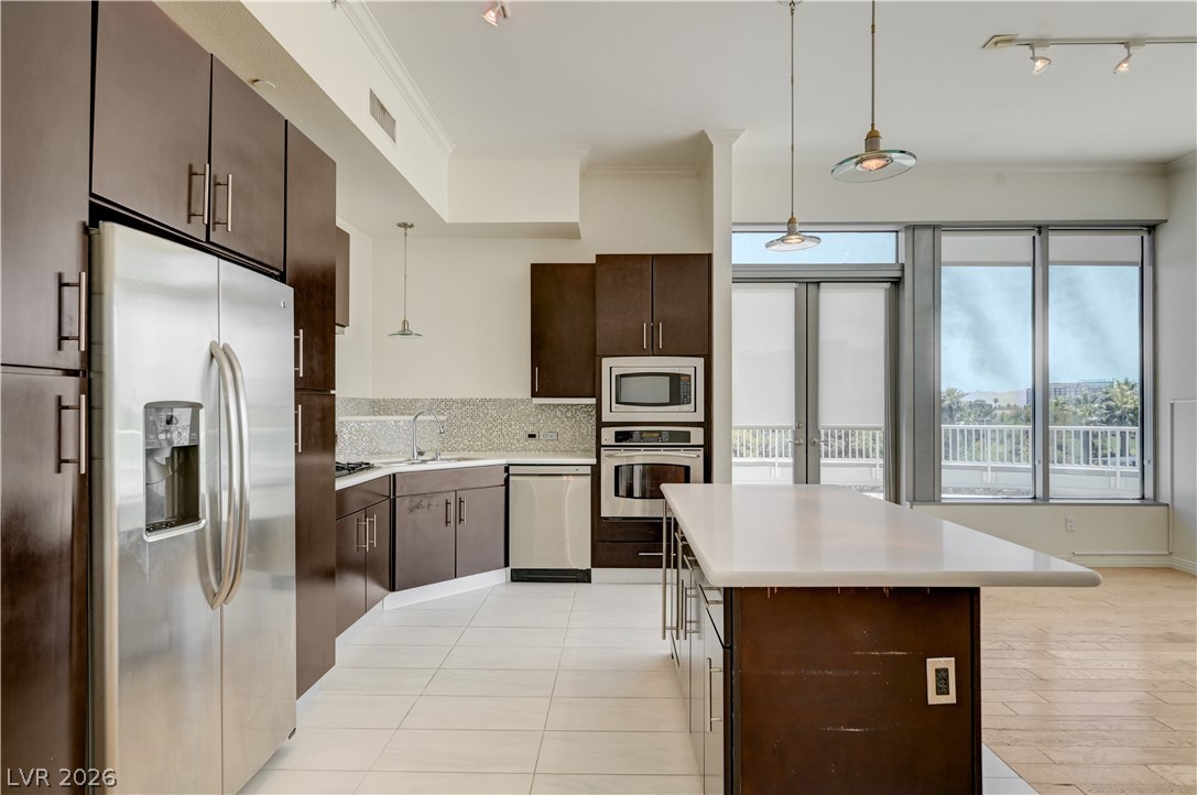 360 East Desert Inn Road, Unit 402 Las Vegas, NV 89109 - Photo 9 of 40 Modern kitchen with stainless steel appliances and balcony access provides a sleek, functional space.