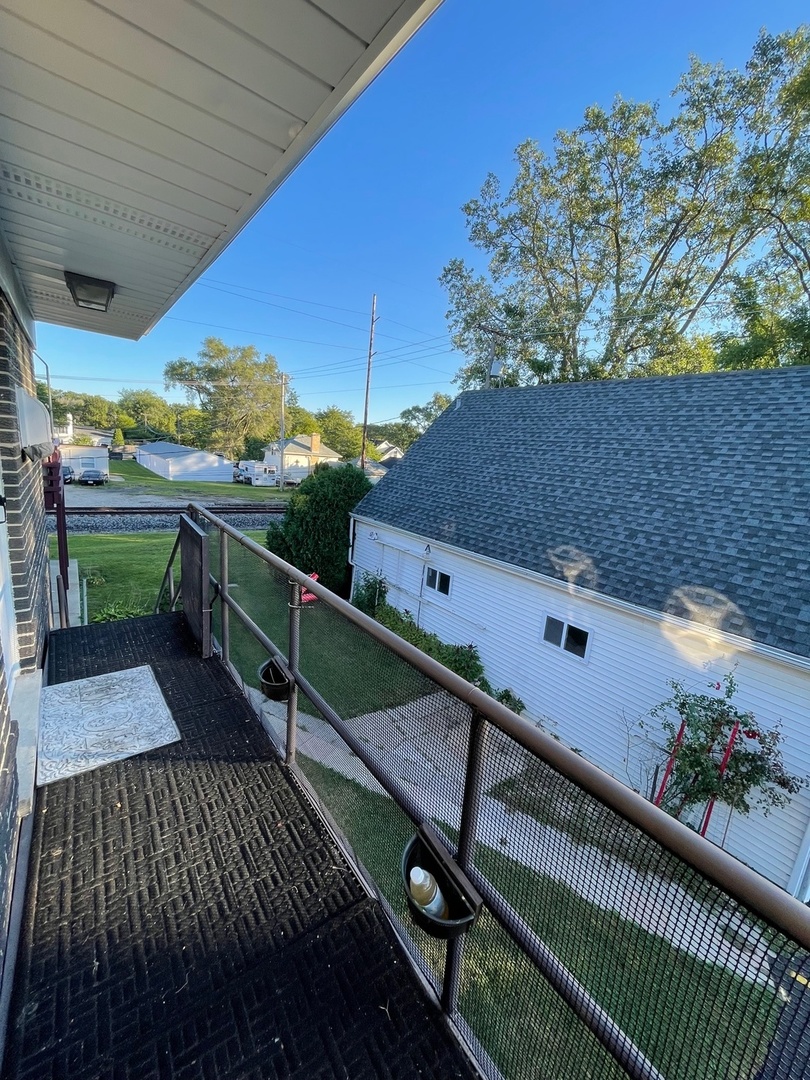 215 Waukegan Road, Unit 2S Lake Bluff, IL 60044 - Photo 23 of 24 a balcony with wooden floor table and chairs