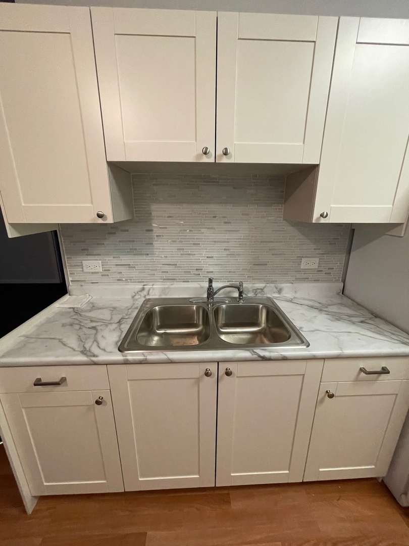 215 Waukegan Road, Unit 2S Lake Bluff, IL 60044 - Photo 8 of 24 a kitchen with white cabinets sink and stove