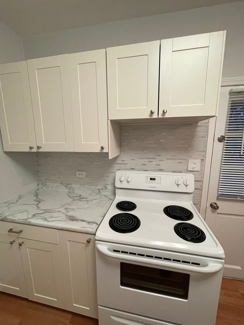 215 Waukegan Road, Unit 2S Lake Bluff, IL 60044 - Photo 9 of 24 a kitchen with a stove and white cabinets