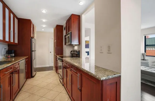 a kitchen with stainless steel appliances granite countertop a refrigerator a stove and a sink