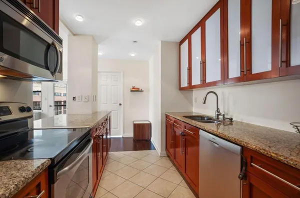 a kitchen with stainless steel appliances granite countertop a sink stove and cabinets