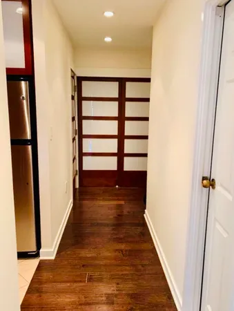 a view of a hallway with wooden floor and staircase