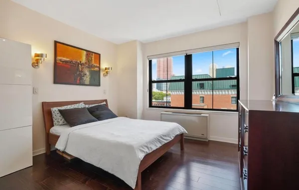 a bedroom with a bed and a large window