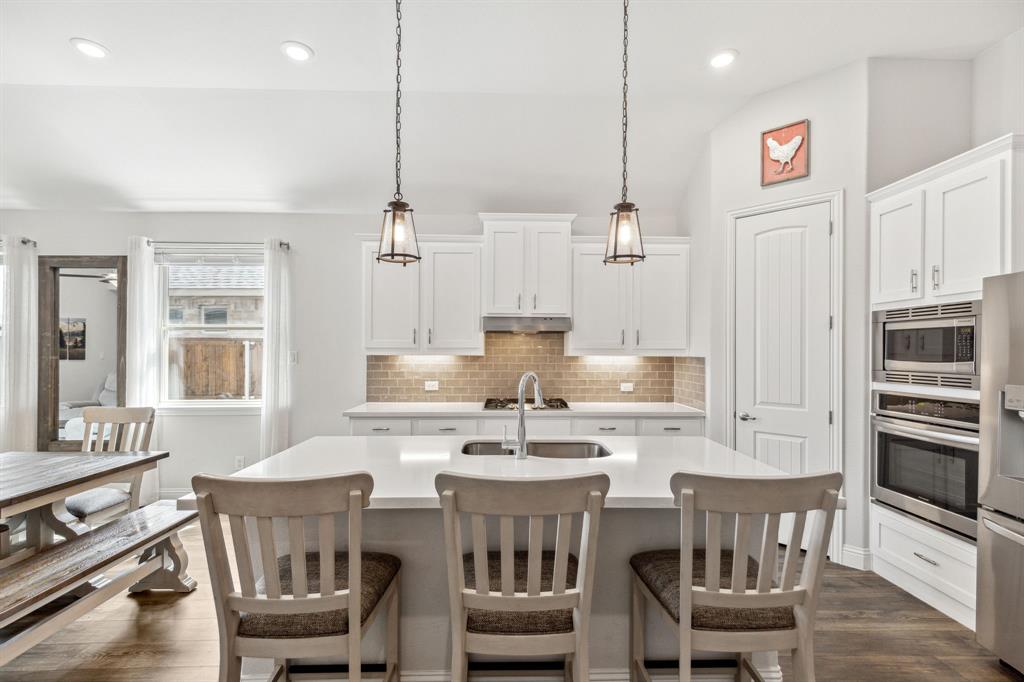 482 Prairie View Drive Haslet, TX 76052 - Photo 7 of 33 a kitchen with kitchen island a dining table chairs stainless steel appliances and cabinets