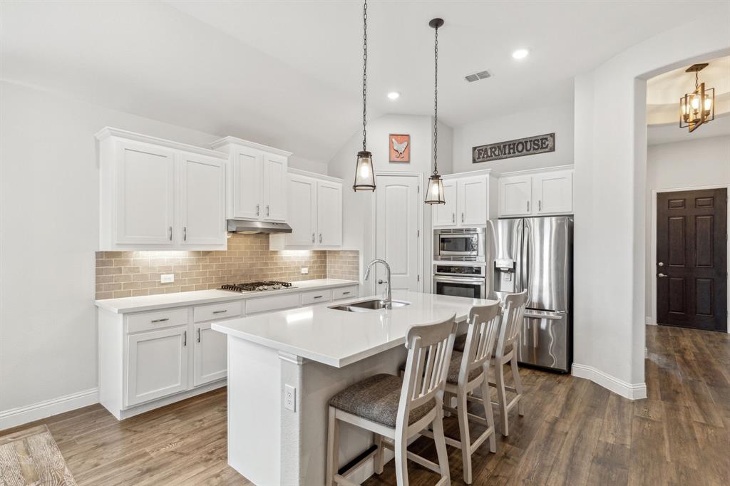 482 Prairie View Drive Haslet, TX 76052 - Photo 8 of 33 a kitchen with stainless steel appliances a stove a sink refrigerator and a wooden cabinets