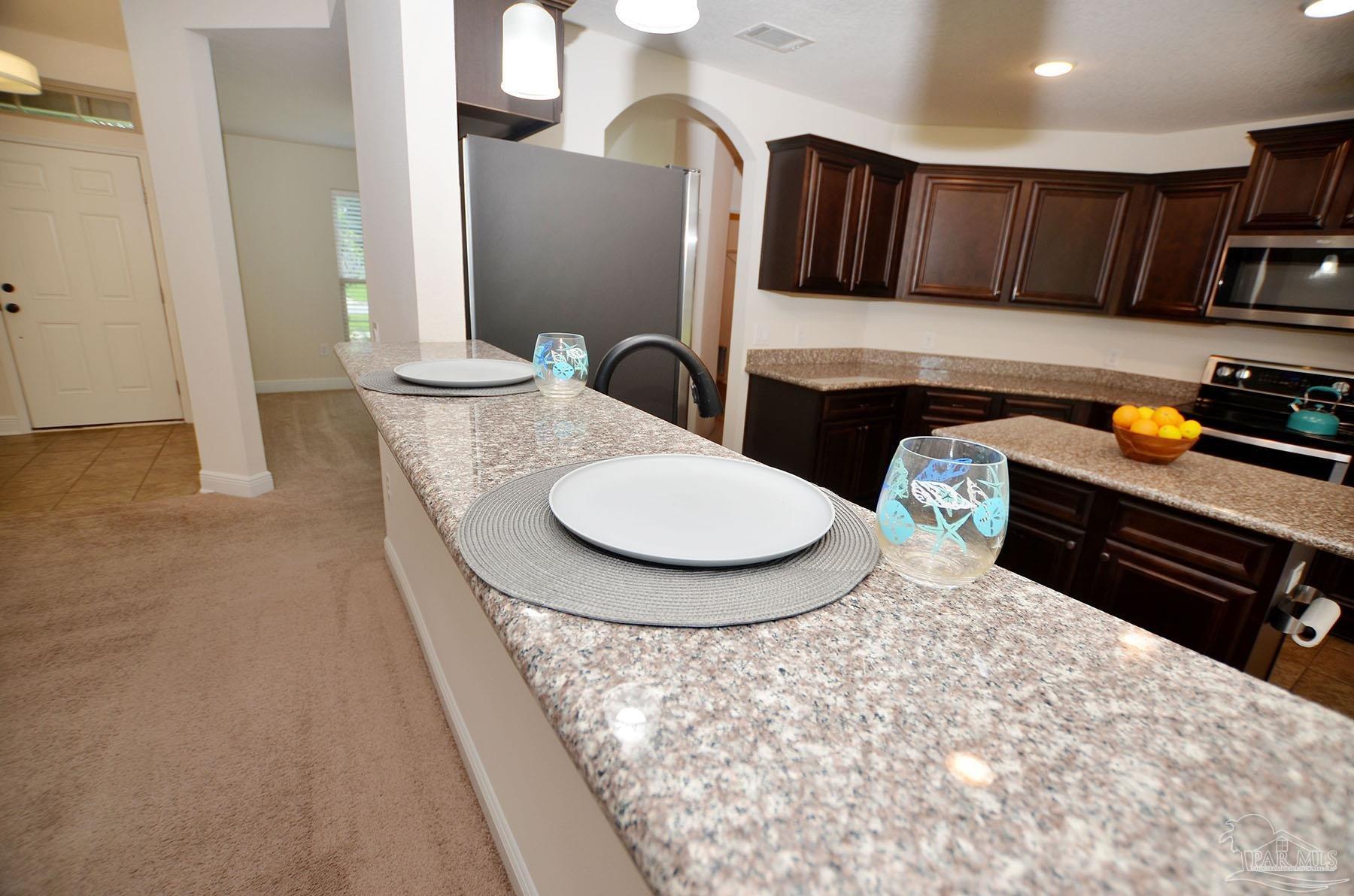 5709 Mill Stream Way Pace, FL 32571 - Photo 17 of 48 a kitchen with stainless steel appliances a stove a sink a refrigerator and cabinets