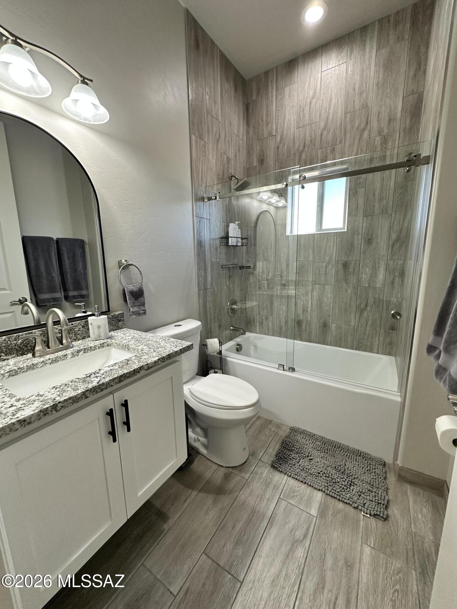 117 Ver Patria Rio Rico, AZ 85648 - Photo 10 of 28 a bathroom with a granite countertop sink toilet a mirror and bathtub