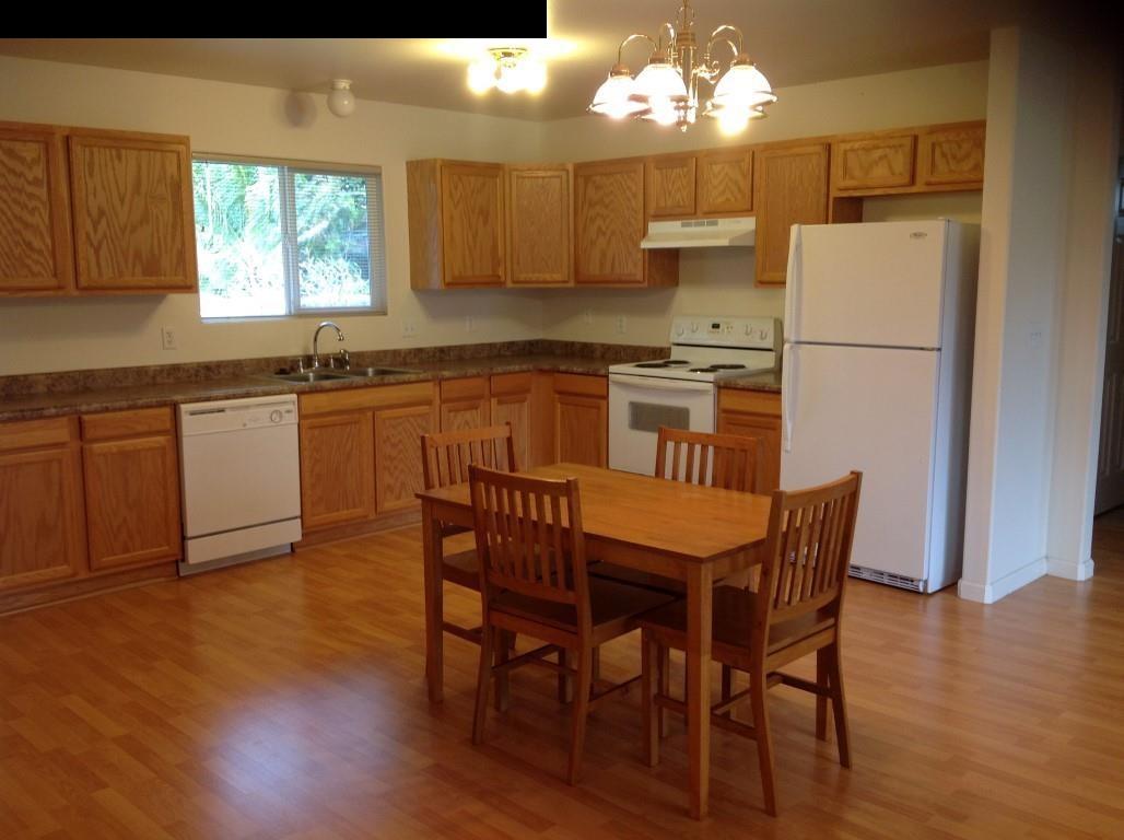 2750 Kokomo Road Haiku, HI 96708 - Photo 4 of 30 a kitchen with stainless steel appliances granite countertop a white refrigerator a sink dishwasher a dining table and chairs with wooden floor