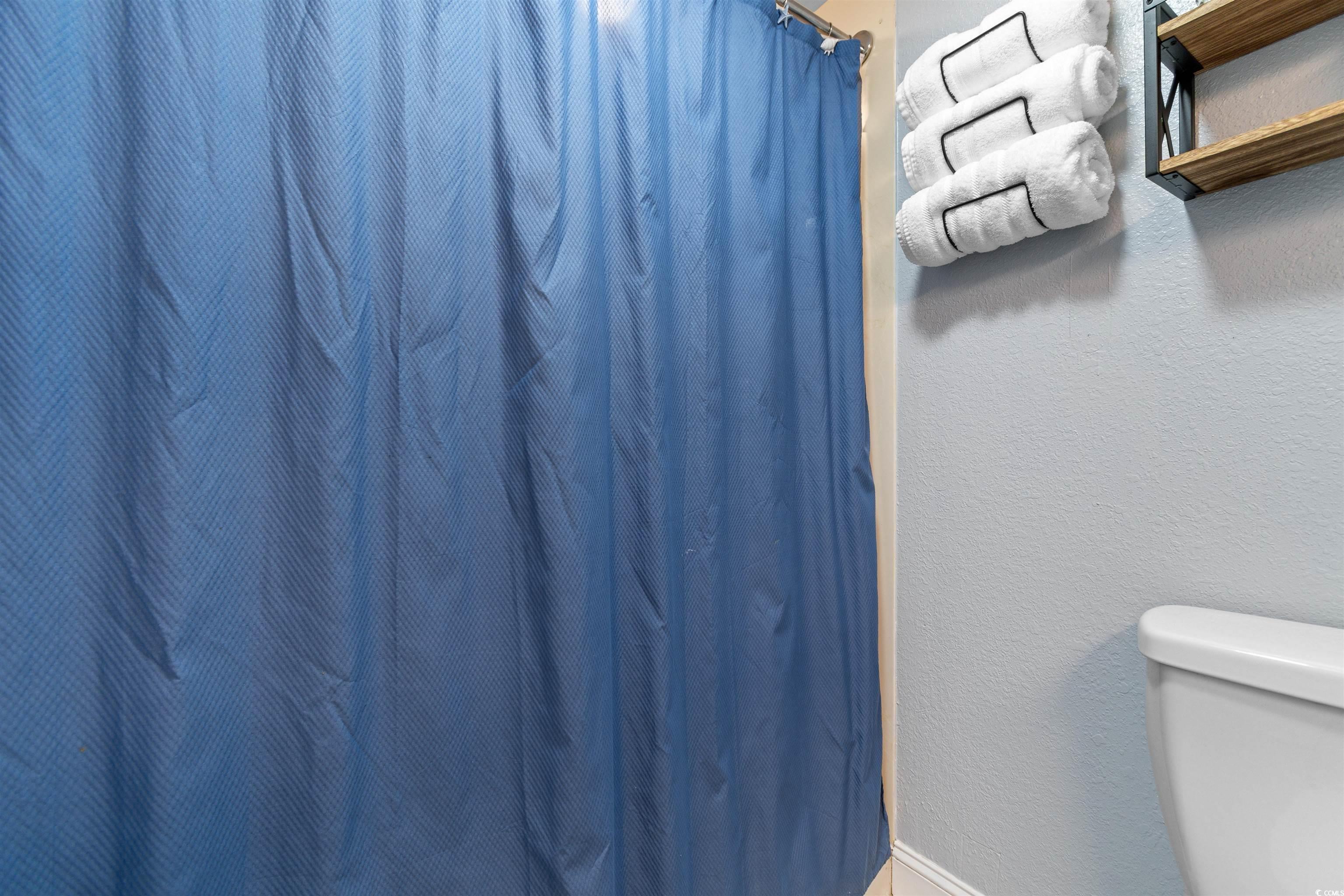 215 77th Avenue North, Unit 603 Myrtle Beach, SC 29572 - Photo 22 of 37 Full bath with a textured wall and a shower with curtain