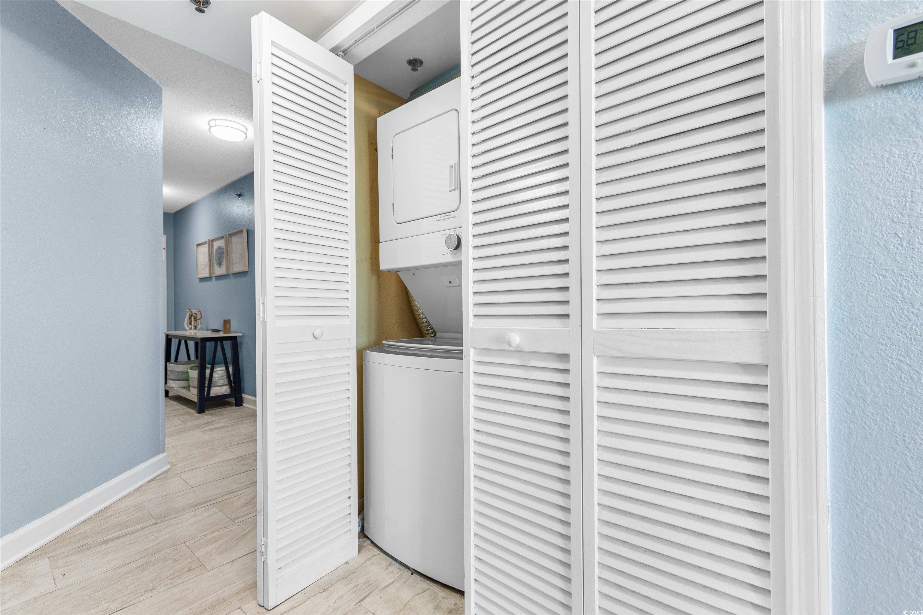 215 77th Avenue North, Unit 603 Myrtle Beach, SC 29572 - Photo 23 of 37 Laundry room with stacked washing machine and dryer and light wood-style floors