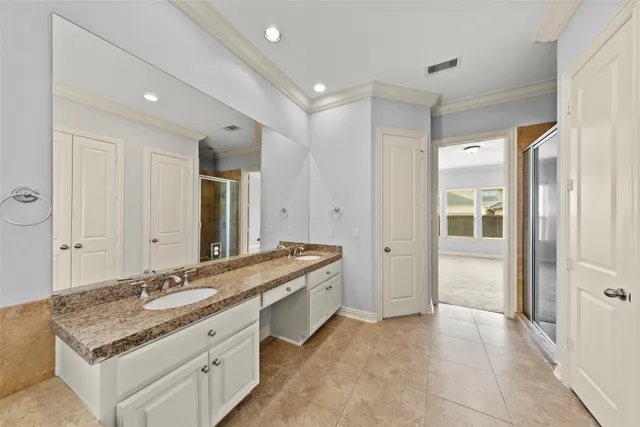 a bathroom with a granite countertop double vanity sink mirror and bathtub