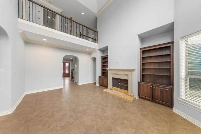 a view of an empty room with a fireplace and a window