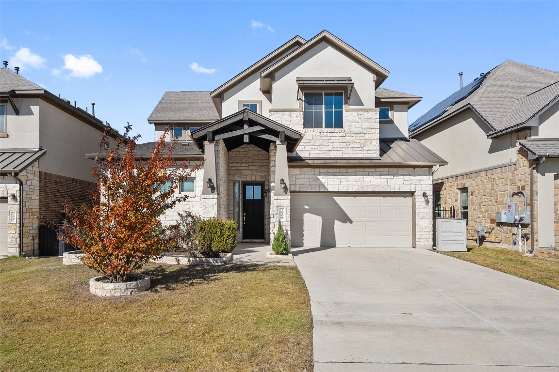 2909 Zelma Drive Cedar Park, TX 78613 - Photo 1 of 40 View of front facade with stone siding, a standing seam roof, driveway, a front yard, and a garage