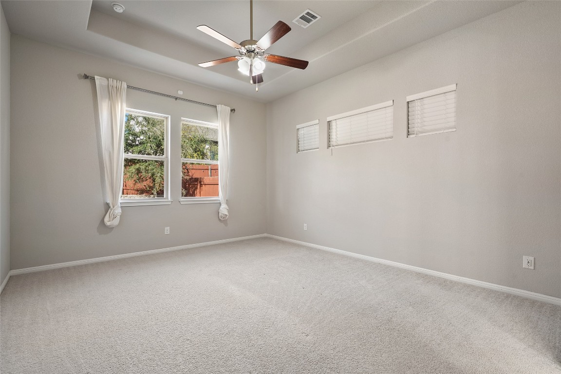 2909 Zelma Drive Cedar Park, TX 78613 - Photo 17 of 40 Empty room featuring carpet flooring, a tray ceiling, and a ceiling fan