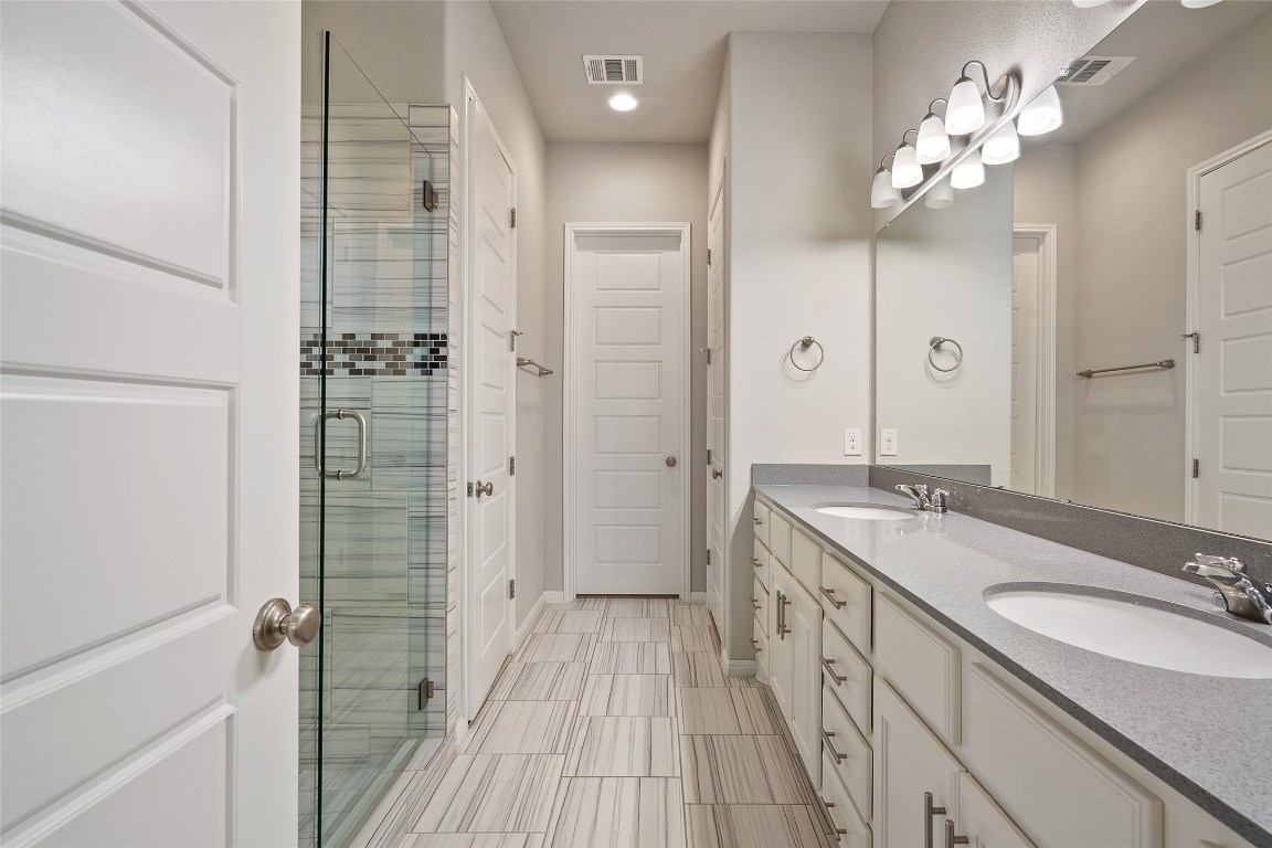 2909 Zelma Drive Cedar Park, TX 78613 - Photo 19 of 40 Bathroom featuring double vanity, a shower stall, and recessed lighting