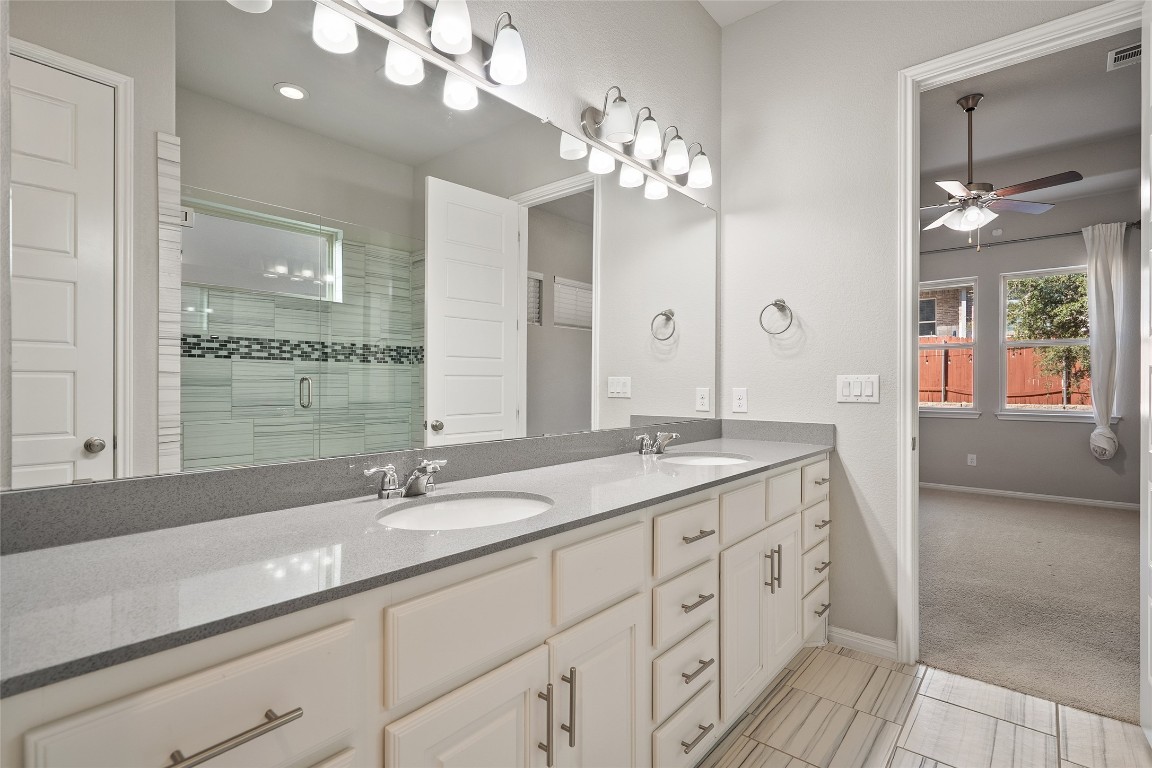 2909 Zelma Drive Cedar Park, TX 78613 - Photo 22 of 40 Full bathroom with double vanity, a stall shower, ceiling fan, light colored carpet, and light tile patterned floors
