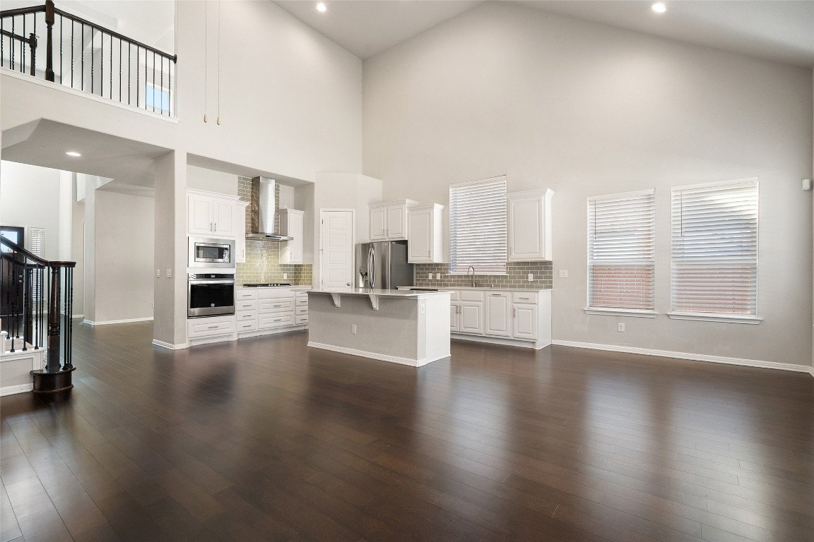 2909 Zelma Drive Cedar Park, TX 78613 - Photo 7 of 40 Unfurnished living room featuring stairs, recessed lighting, a towering ceiling, and dark wood finished floors