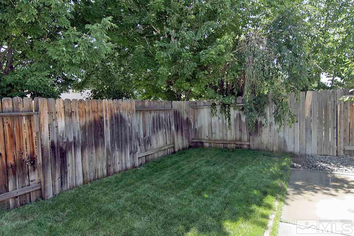 1880 Jamboree Drive Reno, NV 89521 - Photo 23 of 26 a view of backyard with large trees and wooden fence