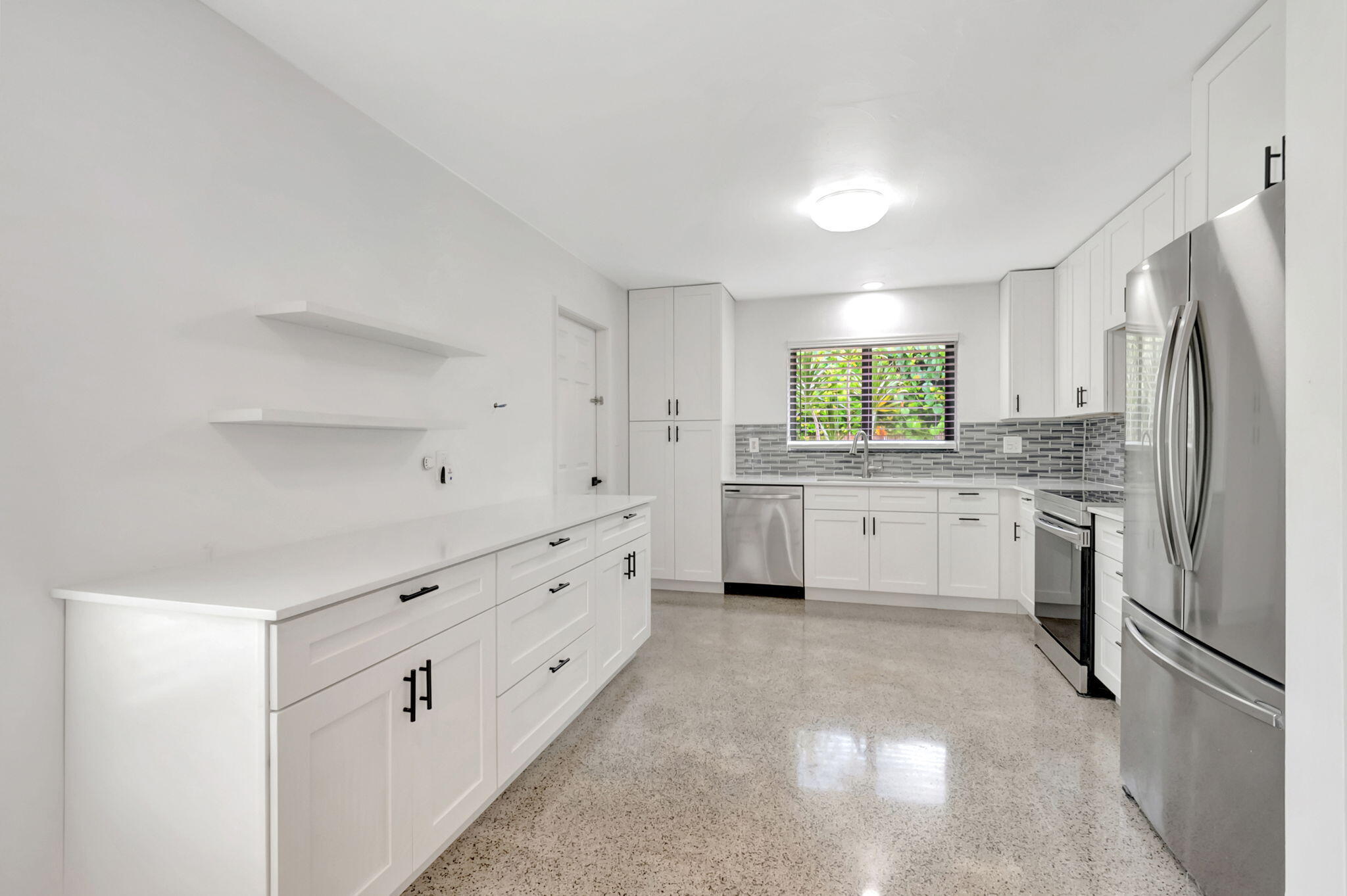 3550 Northeast 4th Avenue Boca Raton, FL 33431 - Photo 7 of 26 a kitchen with white cabinets stainless steel appliances and a window