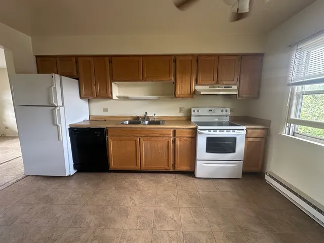 a kitchen with stainless steel appliances a stove a sink and a refrigerator