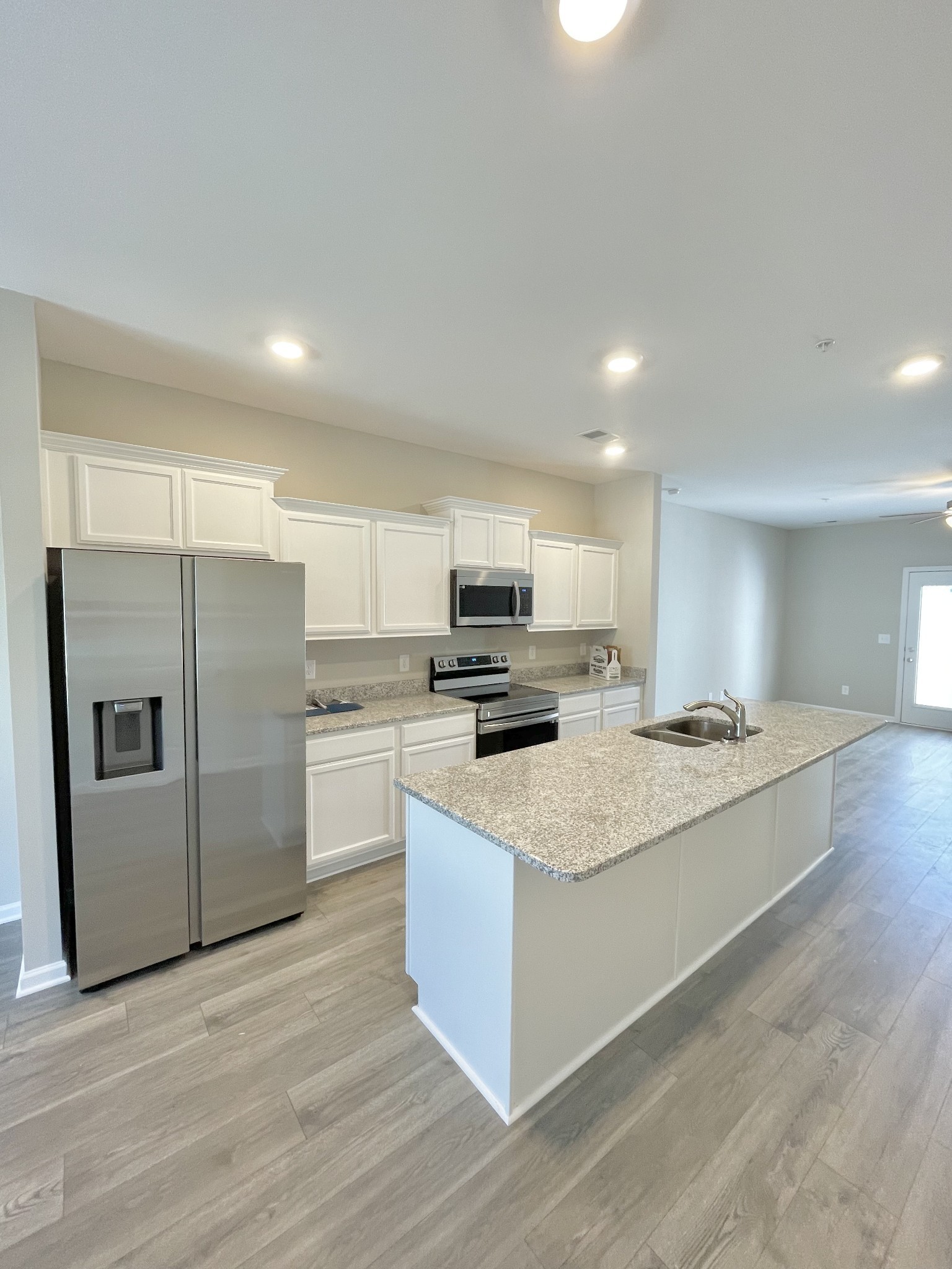 207 Addi Street Pleasant View, TN 37146 - Photo 5 of 13 a kitchen with stainless steel appliances granite countertop a stove top oven a refrigerator and white cabinets