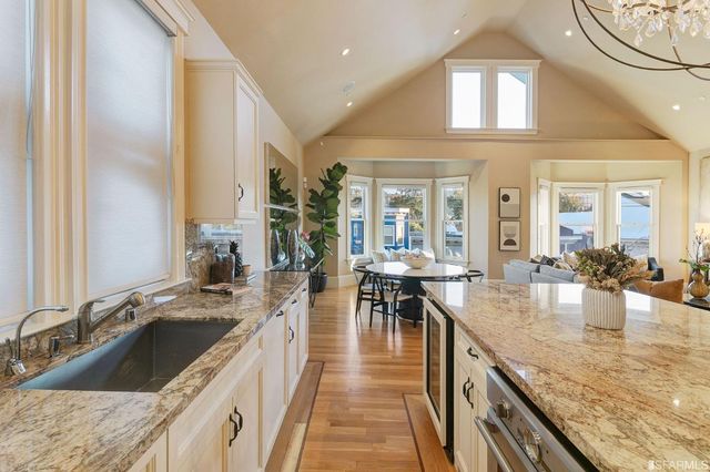 a kitchen with kitchen island granite countertop a table and chairs in it