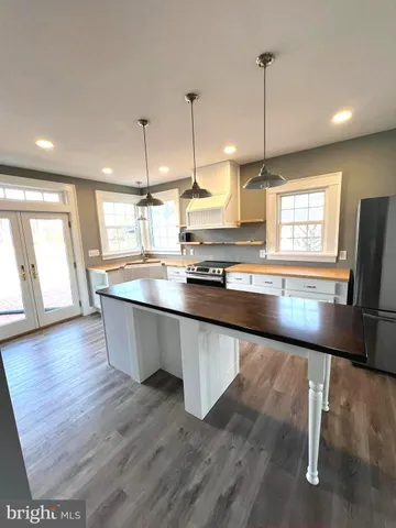 a kitchen with stainless steel appliances granite countertop a sink a window and wooden floor
