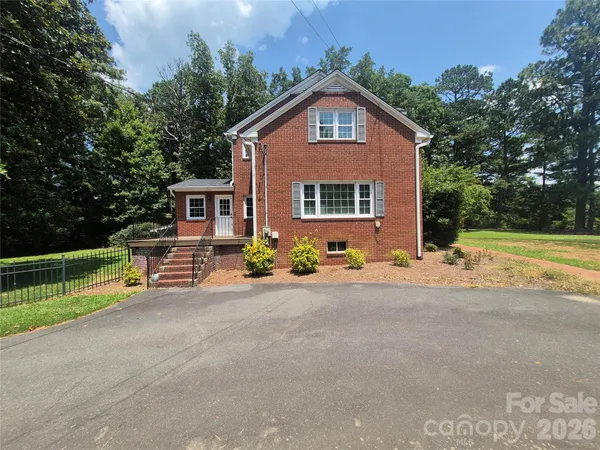 a view of a house with a yard and sitting area