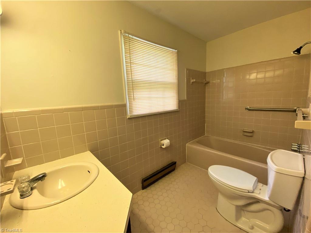 6603 Company Mill Road Climax, NC 27233 - Photo 12 of 24 Here is the hall full bath. The neutral tile is in good shape and you can see it has a tub/shower combo.