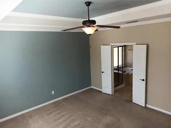 a view of a room with a ceiling fan and refrigerator