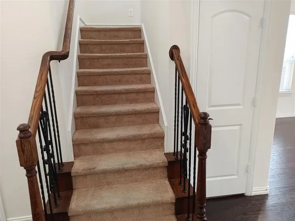 a view of stairs and hall with wooden floor