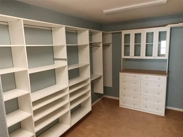 a view of walk in closet with empty racks