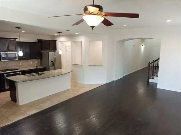 a view of kitchen with stainless steel appliances refrigerator stove microwave and cabinets