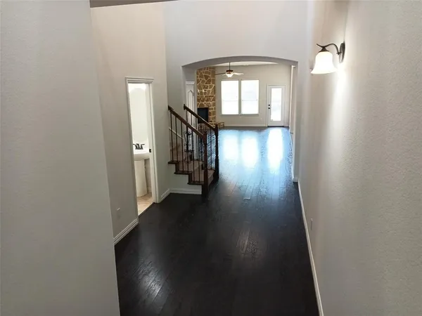 a view of a hallway with wooden floor and a living room