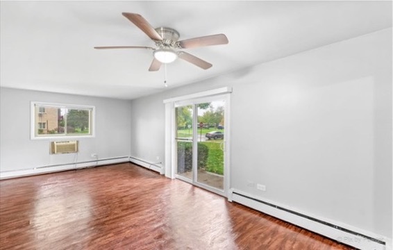 1050 North Wheeling Road, Unit 2B Mount Prospect, IL 60056 - Photo 12 of 13 an empty room with wooden floor fan and windows